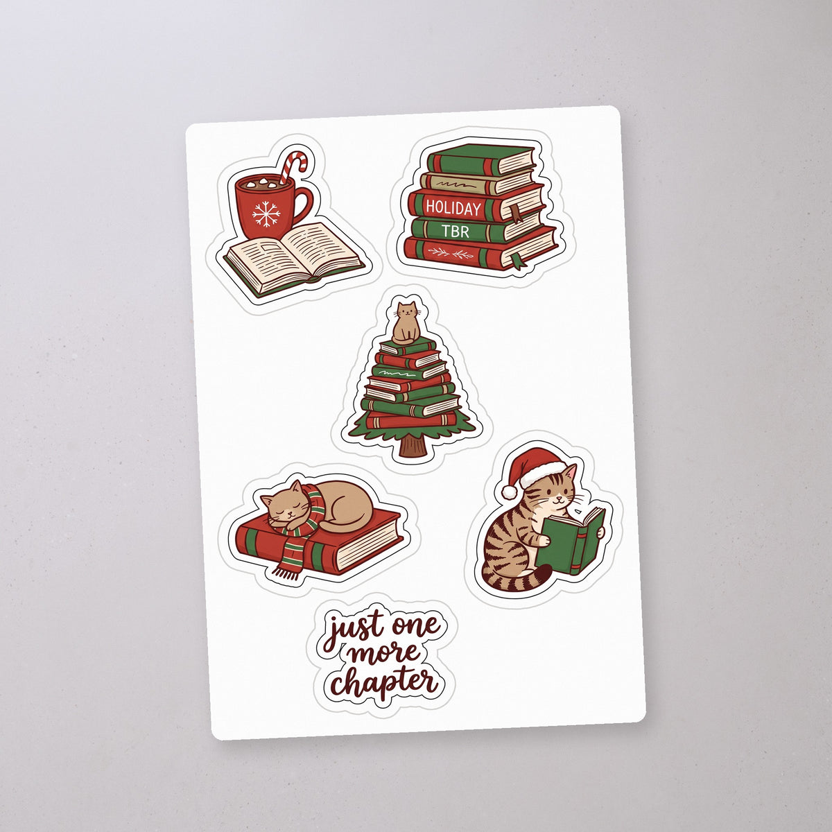Holiday Reading Cat Sticker Sheet, sticker sheet on a concrete floor