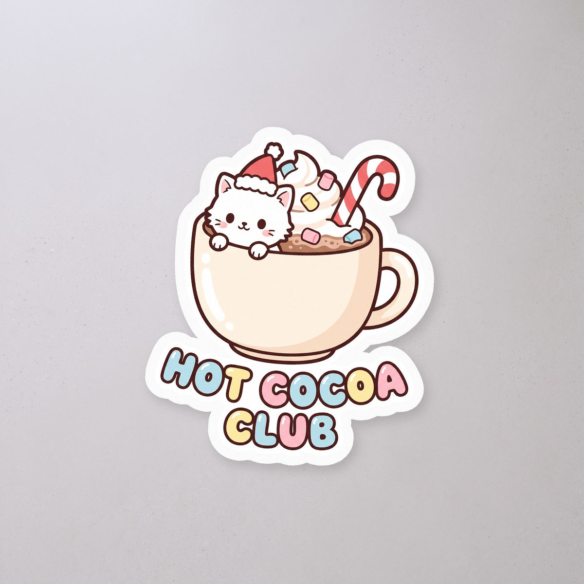 Hot Cocoa Club Cat Sticker on a concrete floor