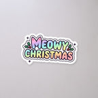 Meowy Christmas Holographic Sticker on a concrete floor